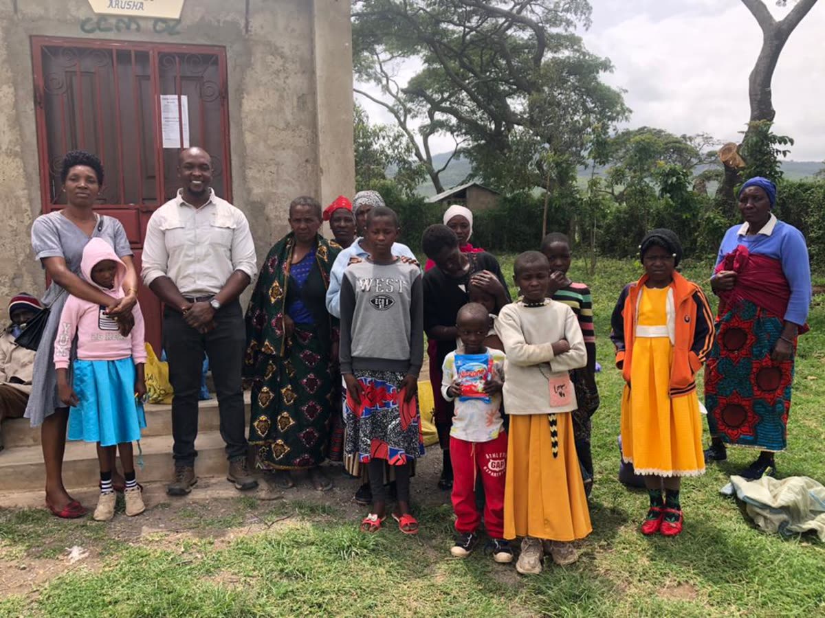 Children and adults of Holley Children Orphanage gathered together outside a building in Arusha.
